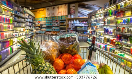 Easter shopping Grocery cart at a colorful supermarket filled up with food products as seen from the customers point of view