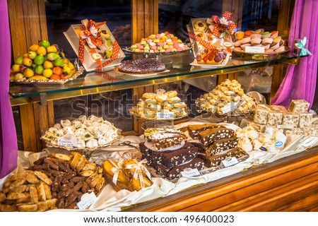 Traditional Italian Pastry shop glass display with selection of nougat, cookies, cake and sweets