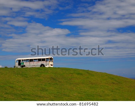 old vintage bus taking the scenery in from the top of a hill