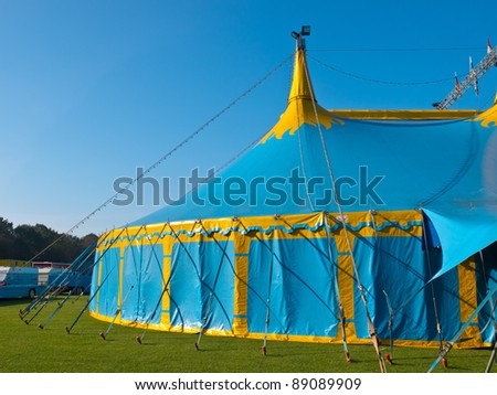 Sideview of a blue and yellow big top circus tent