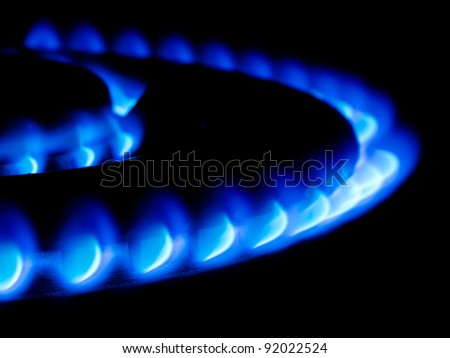 blue flames from a double ring giant gas stove in the dark