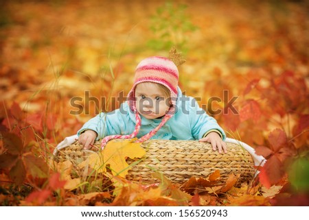 baby with Down syndrome is resting in autumn forest