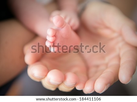 little feet in Daddy\'s hands
