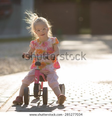 beautiful girl with Down syndrome riding a bike