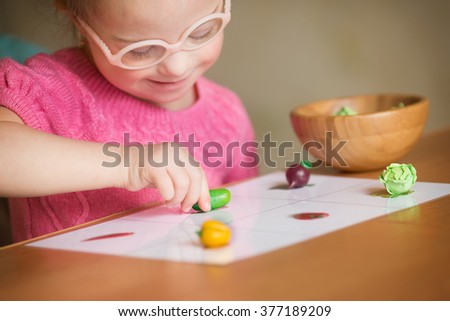 Girl with Down syndrome with interest sorting vegetables