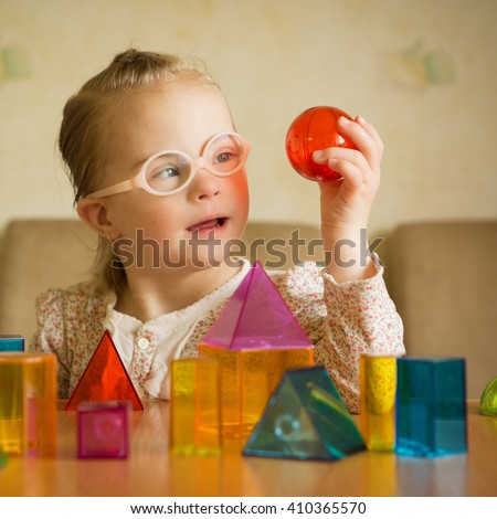 Girl with Down syndrome playing with geometrical shapes