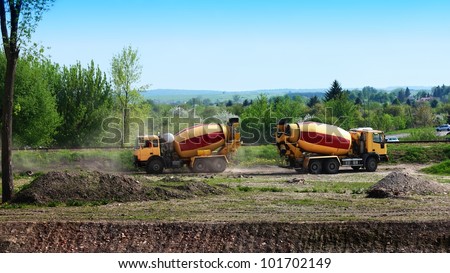 Two concrete mixer lorries working at building site