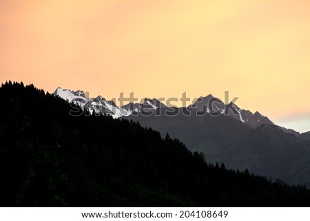 Mountain silhouettes in the austrian apls during sunset.