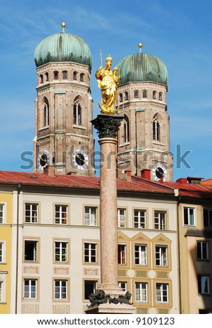 The golden sculpture of Saint Mary with the Church of Our Lady (Frauenkirche) in the background. View from the Marienplatz in Munich (Germany, Bavaria)