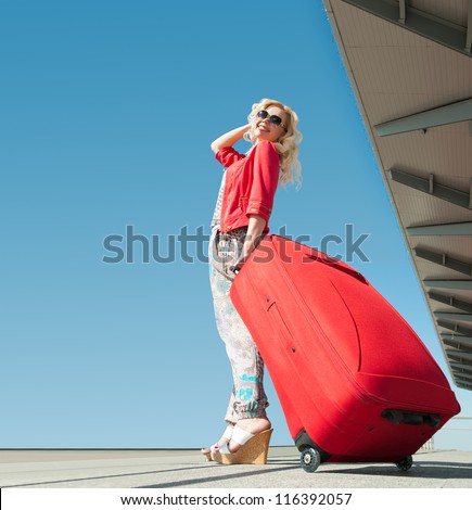 girl goes on vacation with red suitcase