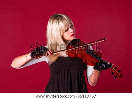girl plays violin with her eyes closed
