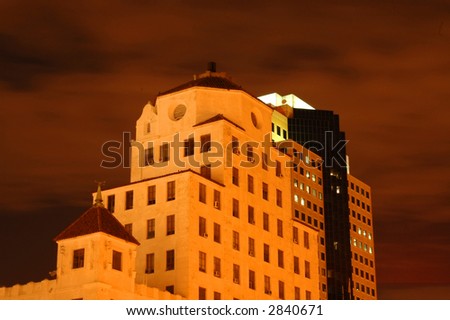 Tall city buildings against a cloudy night sky