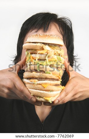 A woman trying to take a bite out of an oversized burger
