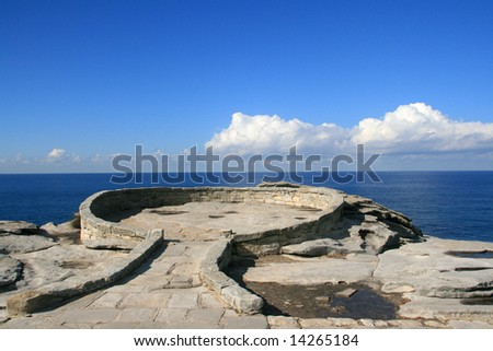 A circular rock lookout point overlooking the sea