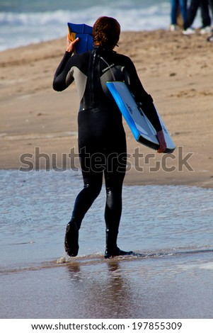 SAN FERNANDO, CADIZ, SPAIN - FEB 19: Unidentified bodyboader leaving the water on the 2nd championship of Surf and BodyBoard Impoxibol on Feb 19,2011 on the beach of San Fernando, Cadiz, Spain