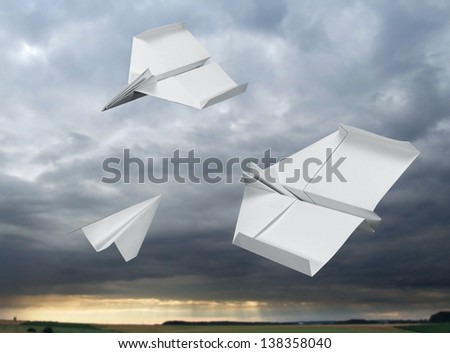 white paper planes flying in stormy back