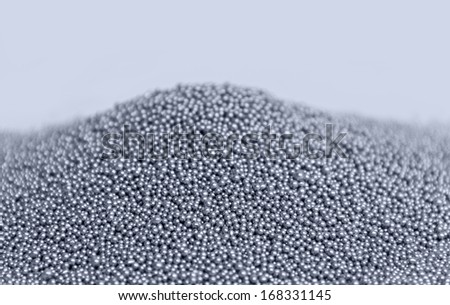 pile of silver metallic beadlets in light back, blue toned