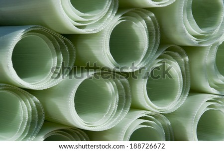 detail of some sunny illuminated light green plastic rolls for agricultural purposes