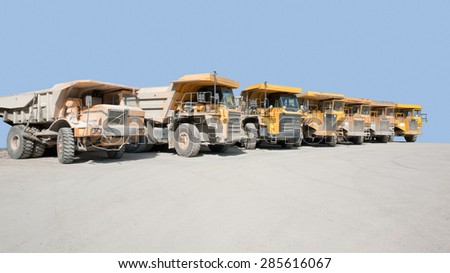 sunny scenery with dirty haul trucks in a row