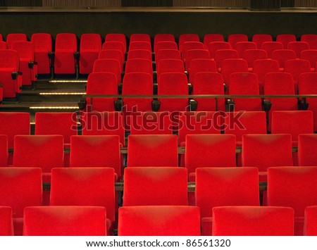 indoor scenery showing a movie theater with red seats in warm ambiance