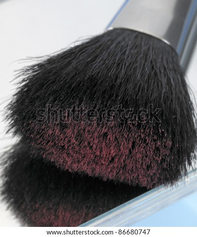 closeup studio shot of a make-up brush with powder particles on tip