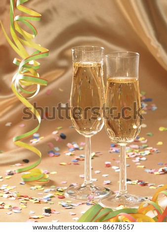 carnival scenery with filled stemware glasses and accessories in floating fabrics back with streamers and confetti