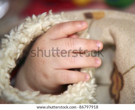 hand of a baby in fury sleeve
