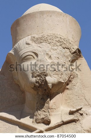 destroyed face of a ancient stone sculpture showing Ramses 2nd in Egypt in sunny ambiance