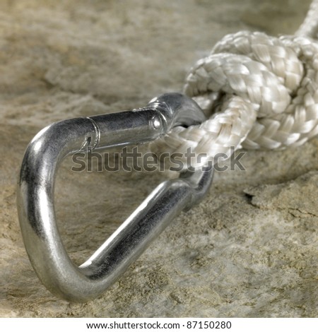 snap hook and rope on stone surface