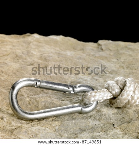snap hook and rope on stone surface