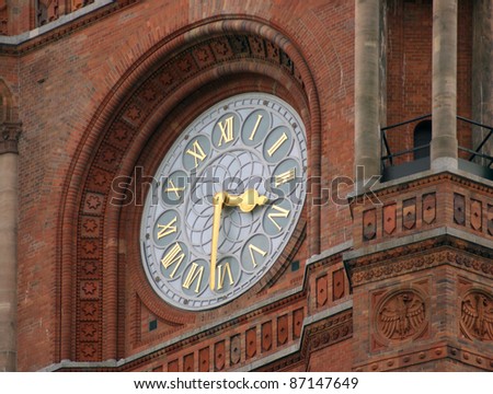 detail of the Red Town Hall in Berlin (Germany) showing the clock surrounded by decorative red brick stone ornaments