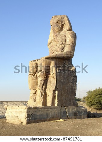southern statue of the Colossi of Memnon, two huge ancient statues near Luxor in Egypt (Africa) at evening time
