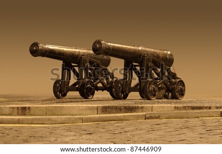 two nostalgic cannons, partly isolated and brown toned
