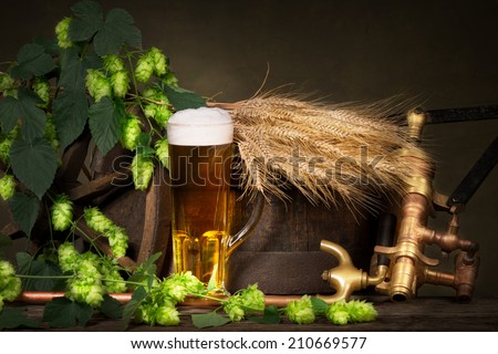 glass of beer with raw material for beer production