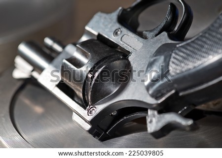 detail of a revolver on the metal desk