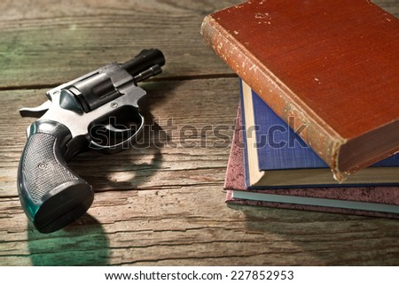 a gun with books on the wooden desk