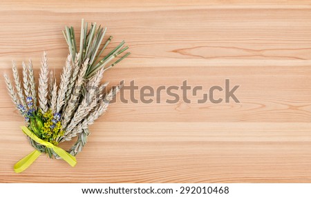 bundle of wheat with flower and band on the wooden desk