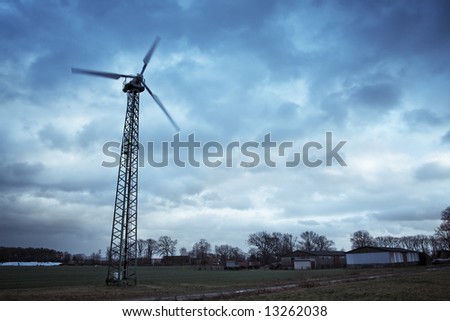 private wind turbine in a rural area in germany against a dramatic  cloudy sky