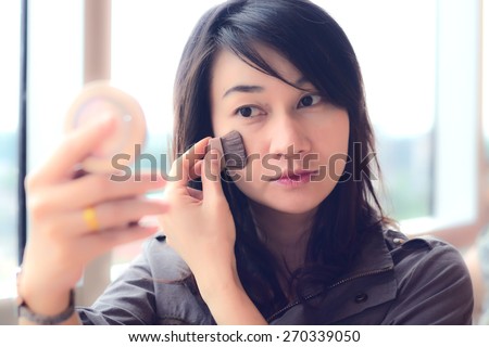 Asia woman makeup your face. Make-up closeup. Cosmetic Powder Brush.