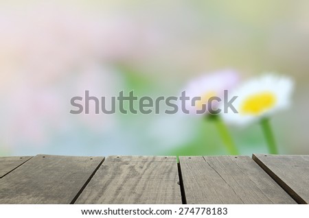 Defocus and blur image of terrace wood and Green daisy garden in morning time for background usage