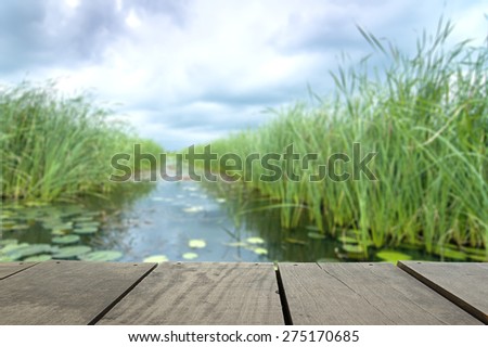 Defocus and blur image of terrace wood and Beautiful lake inside home background usage