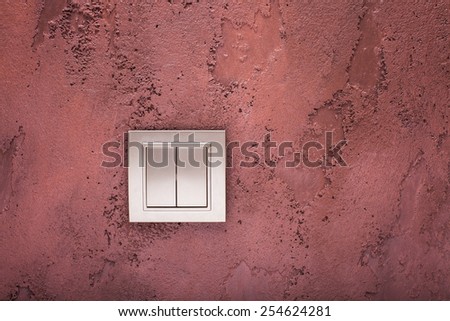 double Light switch/ gold light switch on textured burgundy wall