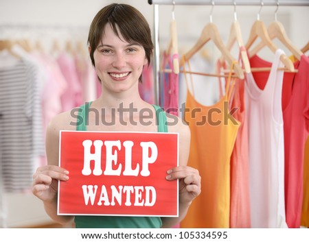 Happy proud owner of store with help wanted sign
