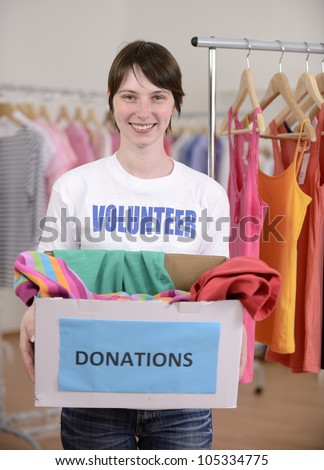Volunteer with clothes donation box at second hand store