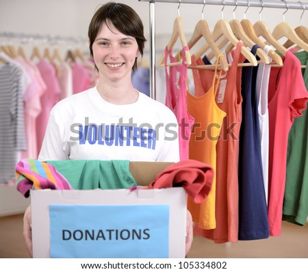 Volunteer with clothes donation box at second hand store