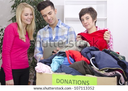 volunteer group with clothing donation and tablet
