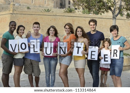 happy and diverse volunteer group holding sign