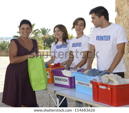 Charity: Happy group of volunteers collecting clothing donations
