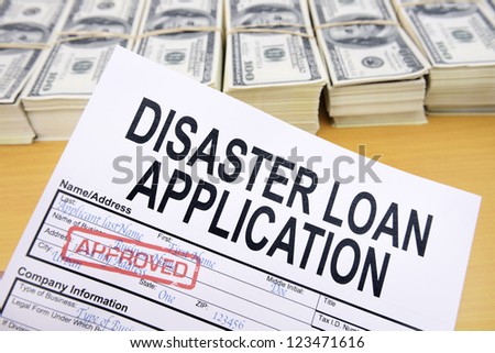 Approved disaster loan application form and dollar bills at cashier\'s desk