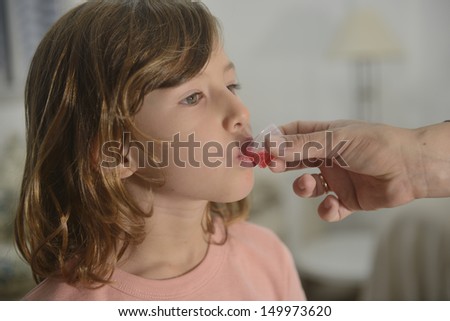Medication: little girl taking cough syrup
